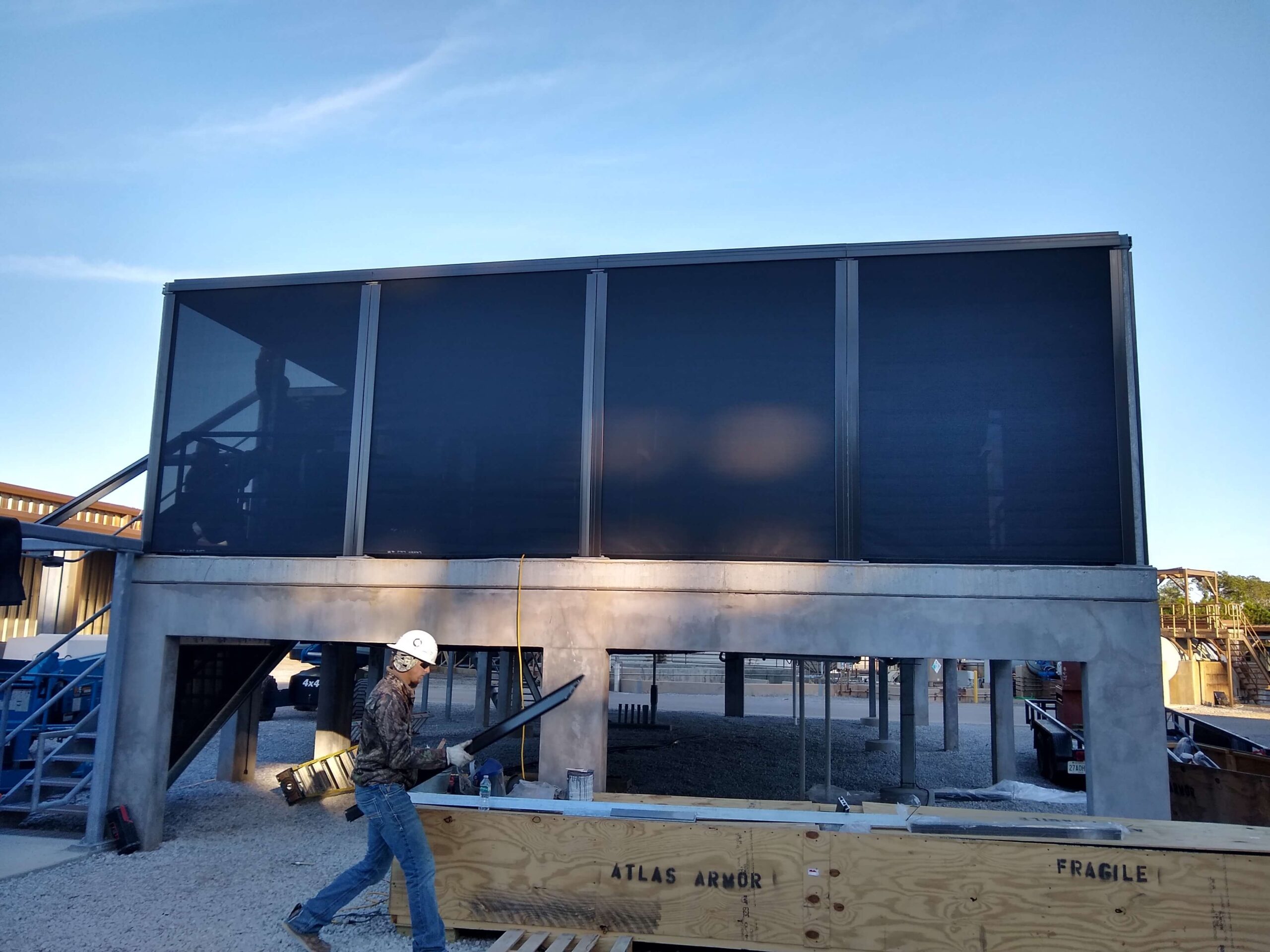 Equipment enclosure protected by hurricane fabric screens